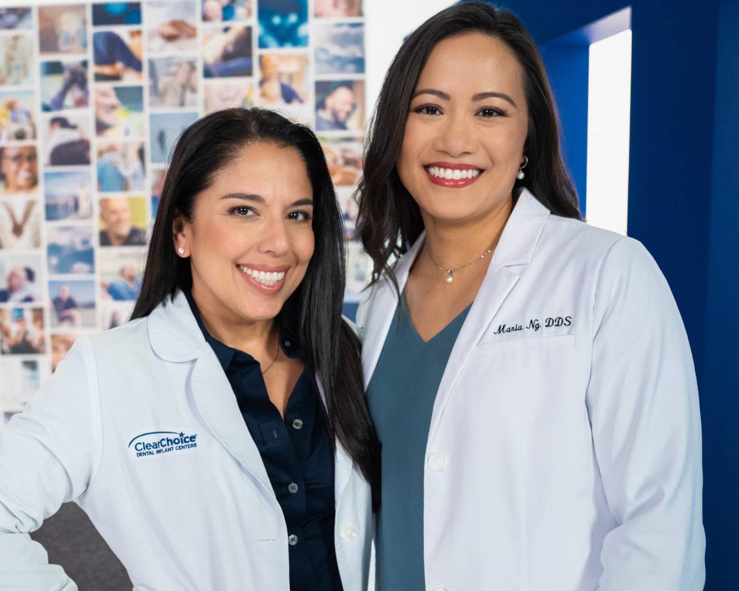 Two female ClearChoice dental professionals in white coats smiling together in a modern clinic setting with a background collage of patient photos, representing expert dental care and friendly service.