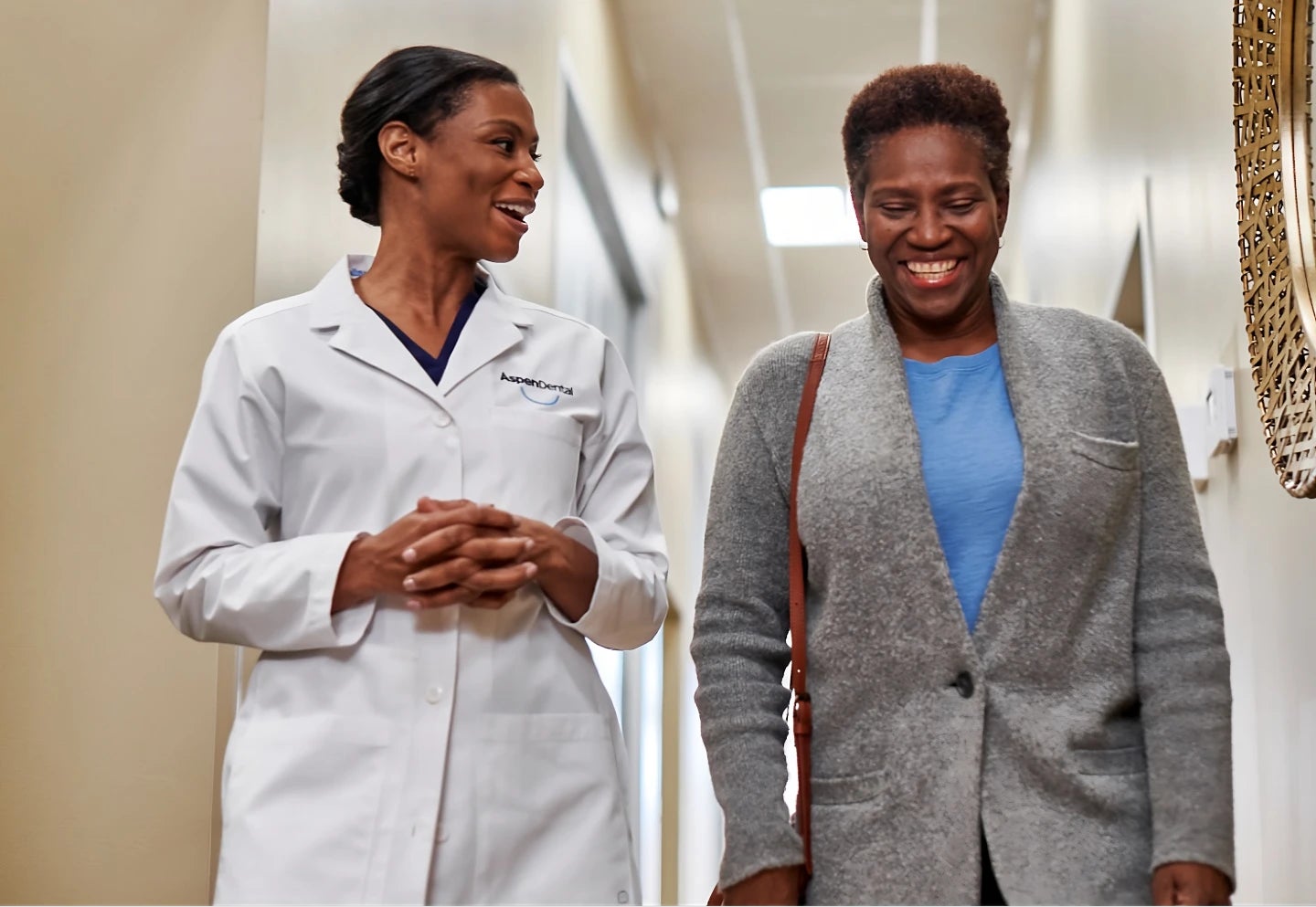 A doctor and a patient are walking down a hallway
