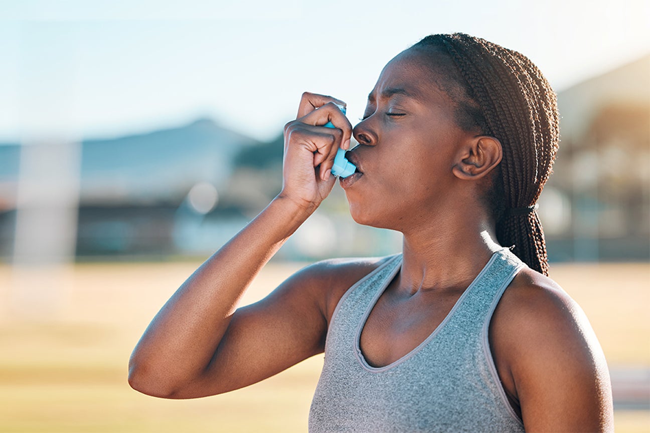 A photo of someone using an inhaler.