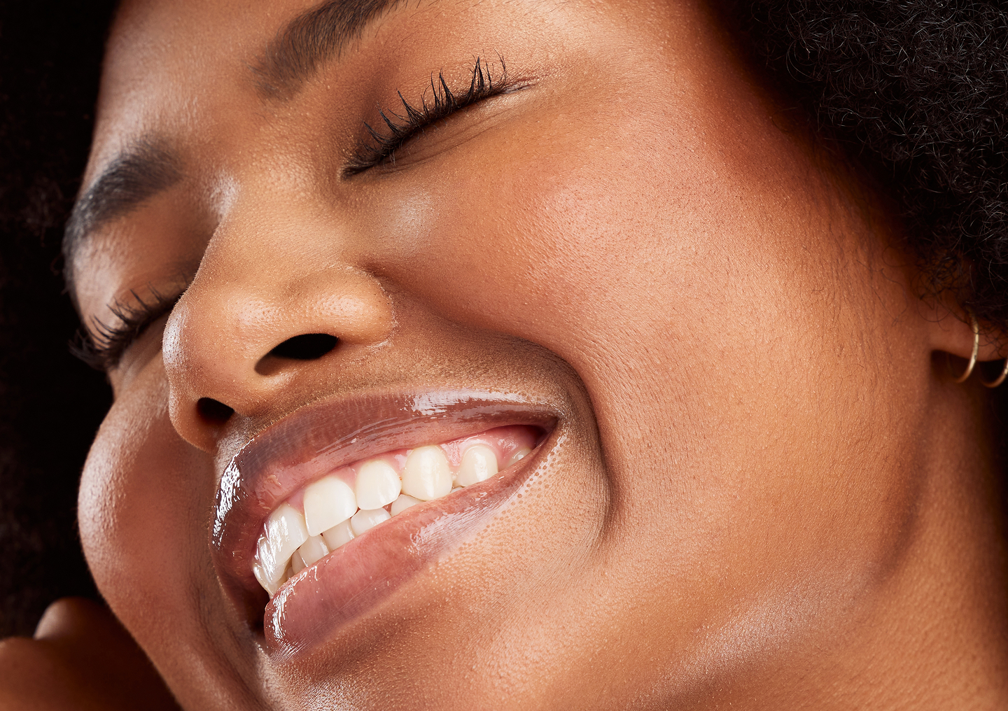 A closeup of a smiling woman's face after receiving a HydraGlow facial at Chapter. Aesthetic Studio