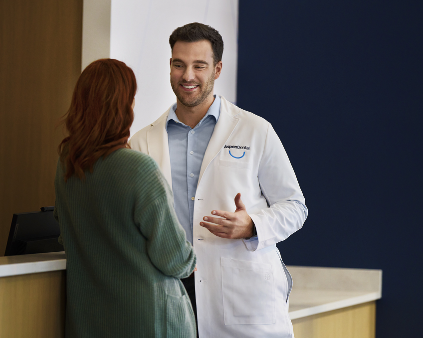 Aspen Dental team member speaking with a patient about the Aspen Dental Savings Plan and affordable dental care options.