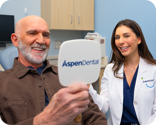 Patient visiting Aspen Dental provider for routine implant denture cleaning and maintenance checkup.