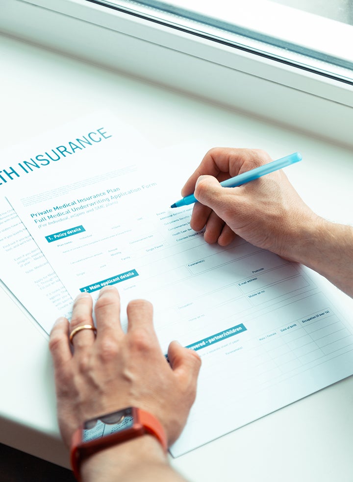 A person is filling out insurance forms