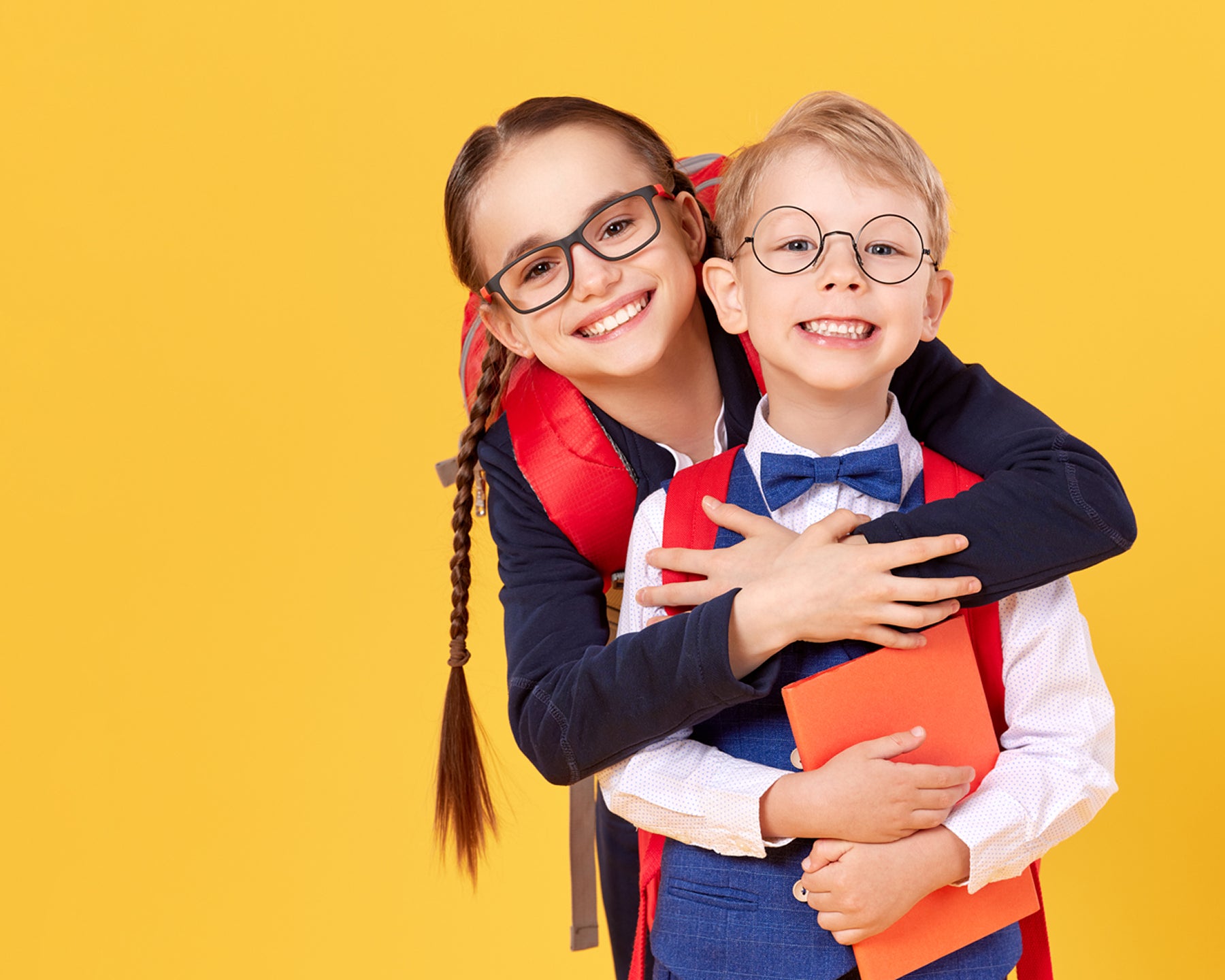 Two happy children on a yellow background.