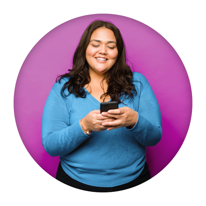 A person happily looking down at their phone and typing a message.