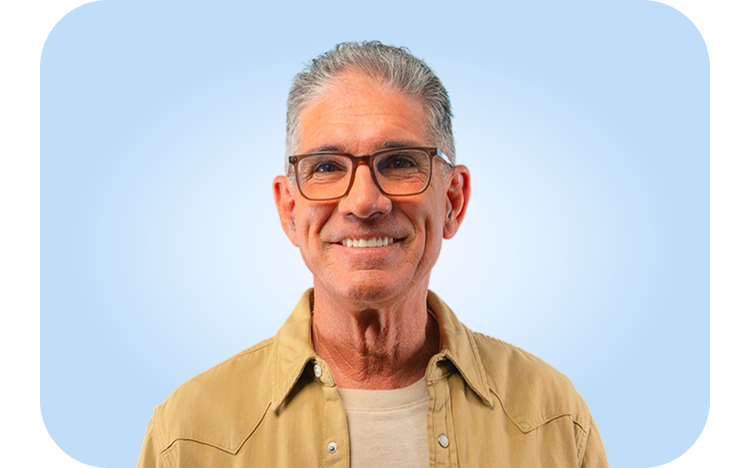  A male Aspen Dental patient shows off his smile after receiving dental implants, showing restored confidence and comfort.