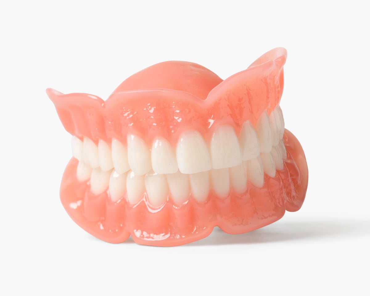 A close up of a denture on a white background