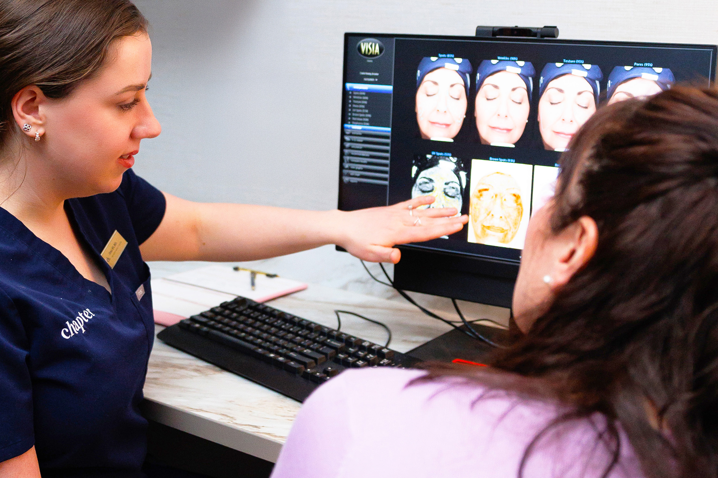 Chapter medical professional consulting a guest on her skin scan, providing a comprehensive analysis and personalized treatment plan for her unique skin needs.