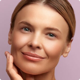 A Chapter patient is smiling and touching her face with her hand