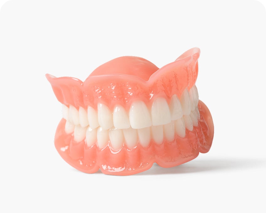A full upper and lower denture set with pink acrylic gums and white teeth is displayed against a white background, representing traditional complete dentures.
