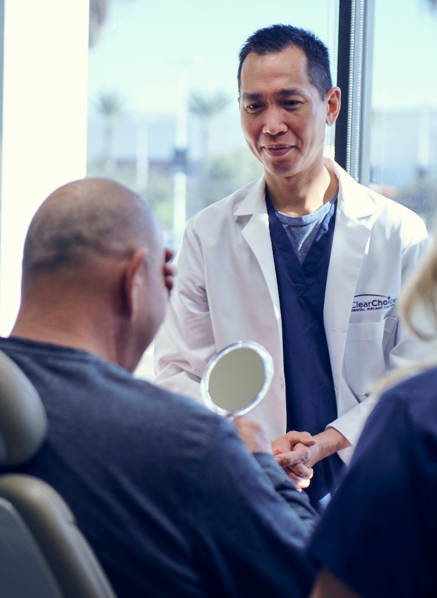 A male clearchoice dentist and male patient after a successful dental implant procedure