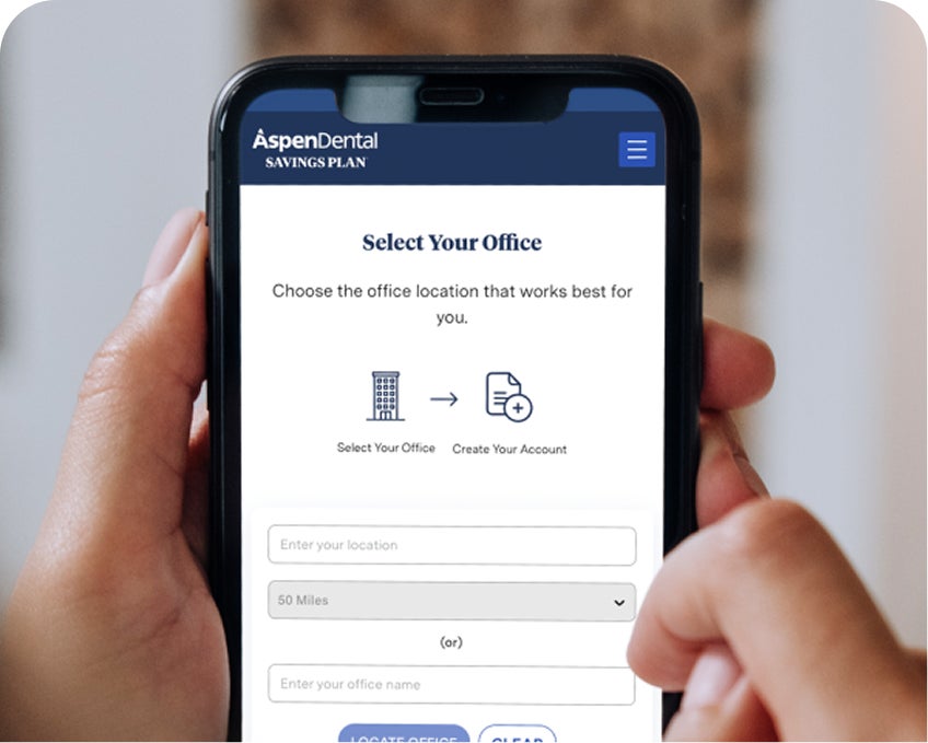 Smiling Aspen Dental professional welcomes patients at the office door, representing the first step in enrolling in the Aspen Dental Savings Plan for affordable, no-judgment dental care.