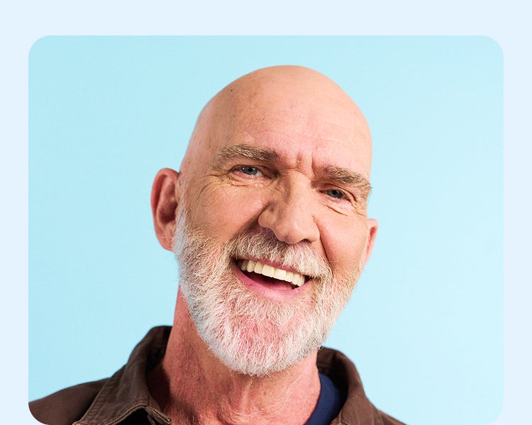 Smiling Aspen Dental patient showing off results of implant dentures, promoting faster treatment and confident smiles.
