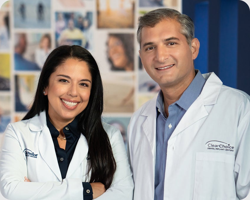 ClearChoice dental implant specialists smiling in a clinical setting. Demonstrates warmth, expertise, and trustworthiness.