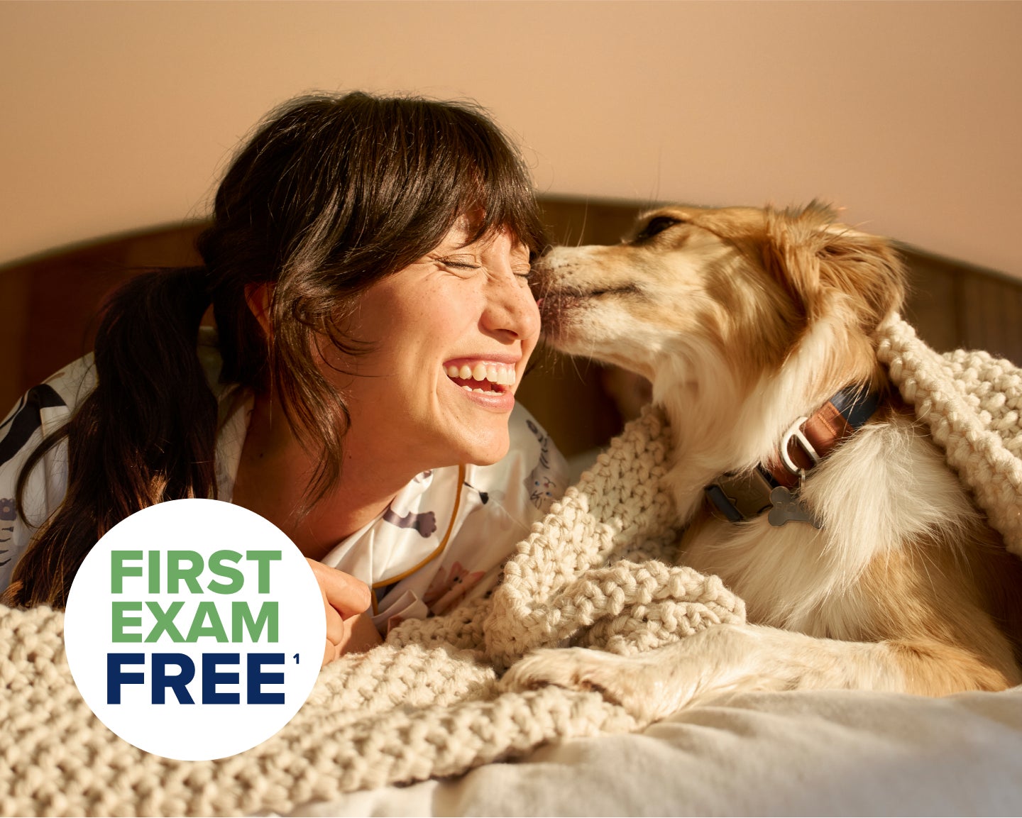 Pet parent cuddling her dog and smiling.