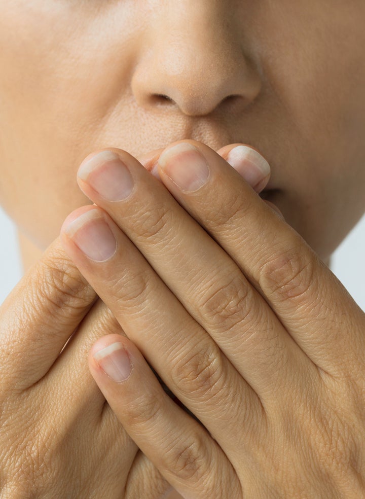 Close-up of a person touching a cold sore on their lip, showing symptoms targeted by fast cold sore treatments. Ideal visual for guides on how to get rid of a cold sore quickly with effective remedies.