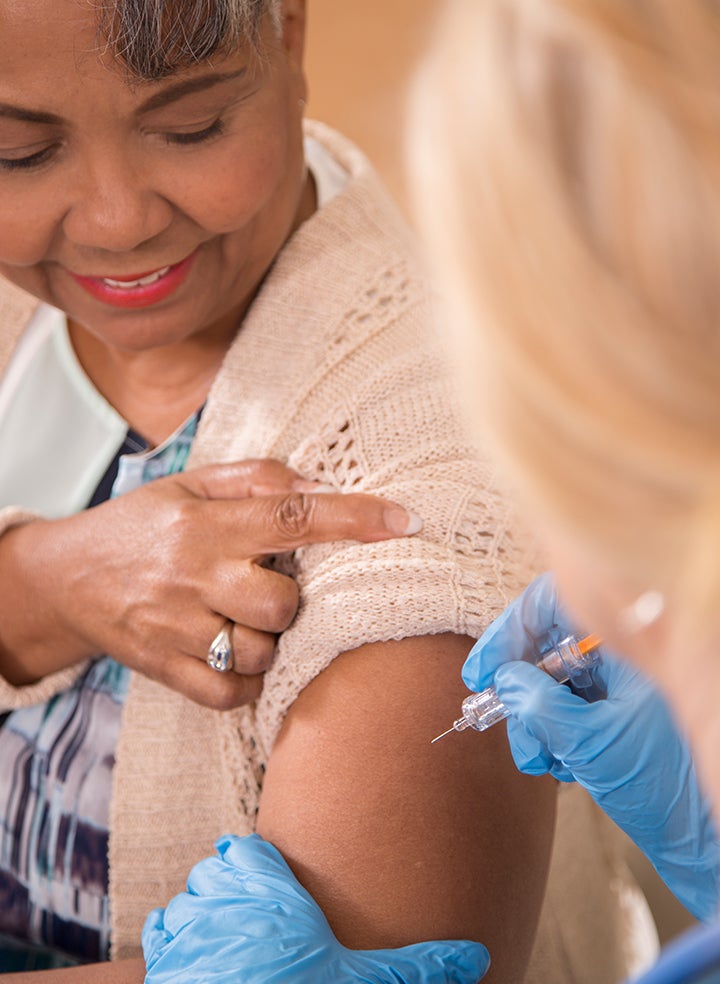 A woman is getting an injection in her arm