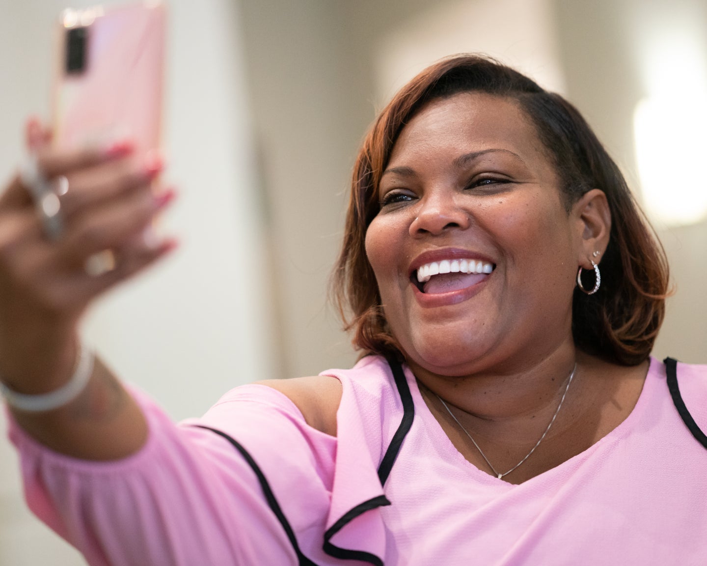 Smiling woman taking a selfie, showcasing the confidence and happiness possible with dental implants, featured in ClearChoice's discussion about whether dental implants are worth the cost.