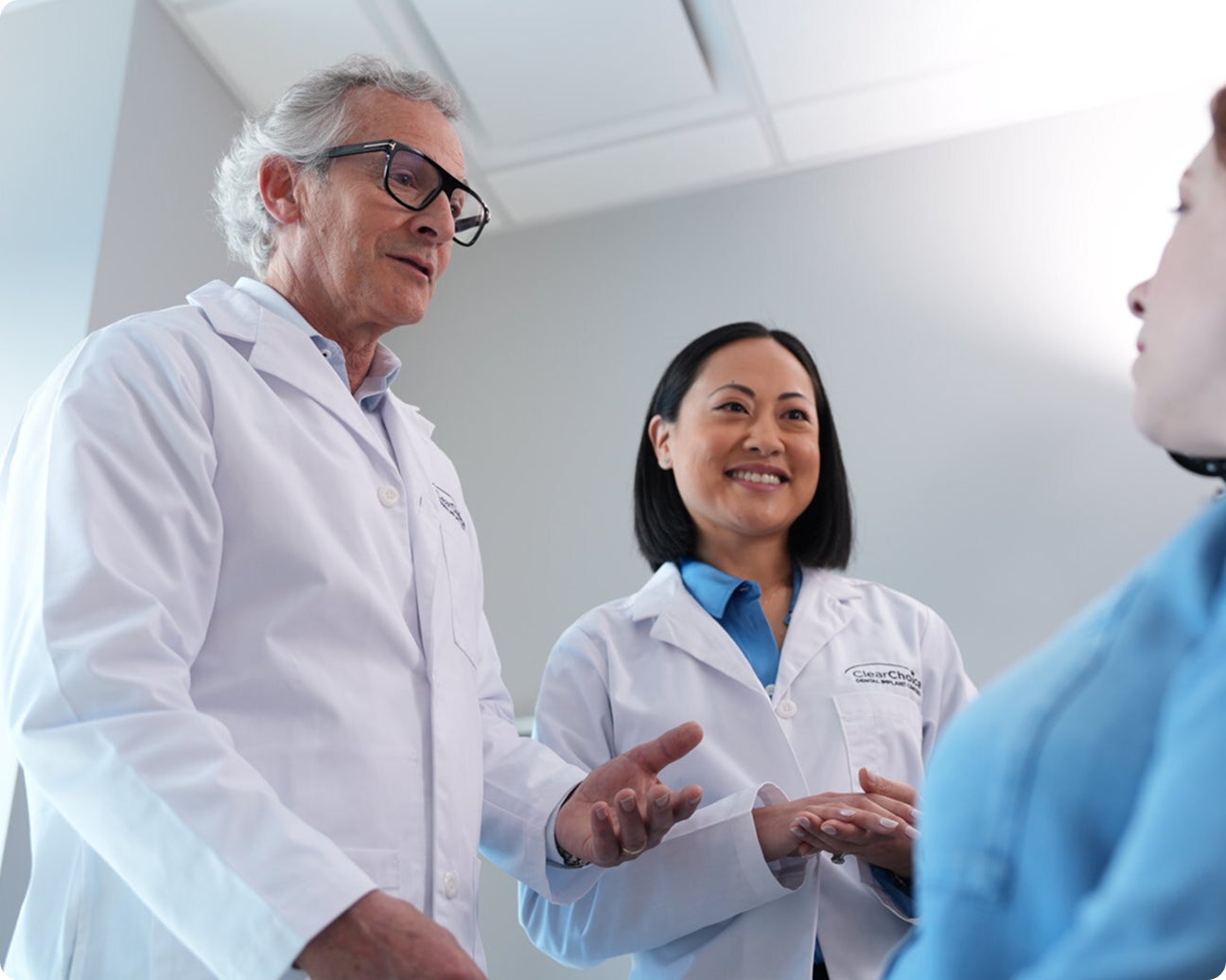 An image of ClearChoice professionals, including experienced prosthodontists and oral surgeons, working together to build a customized, long-lasting smile for their patient.