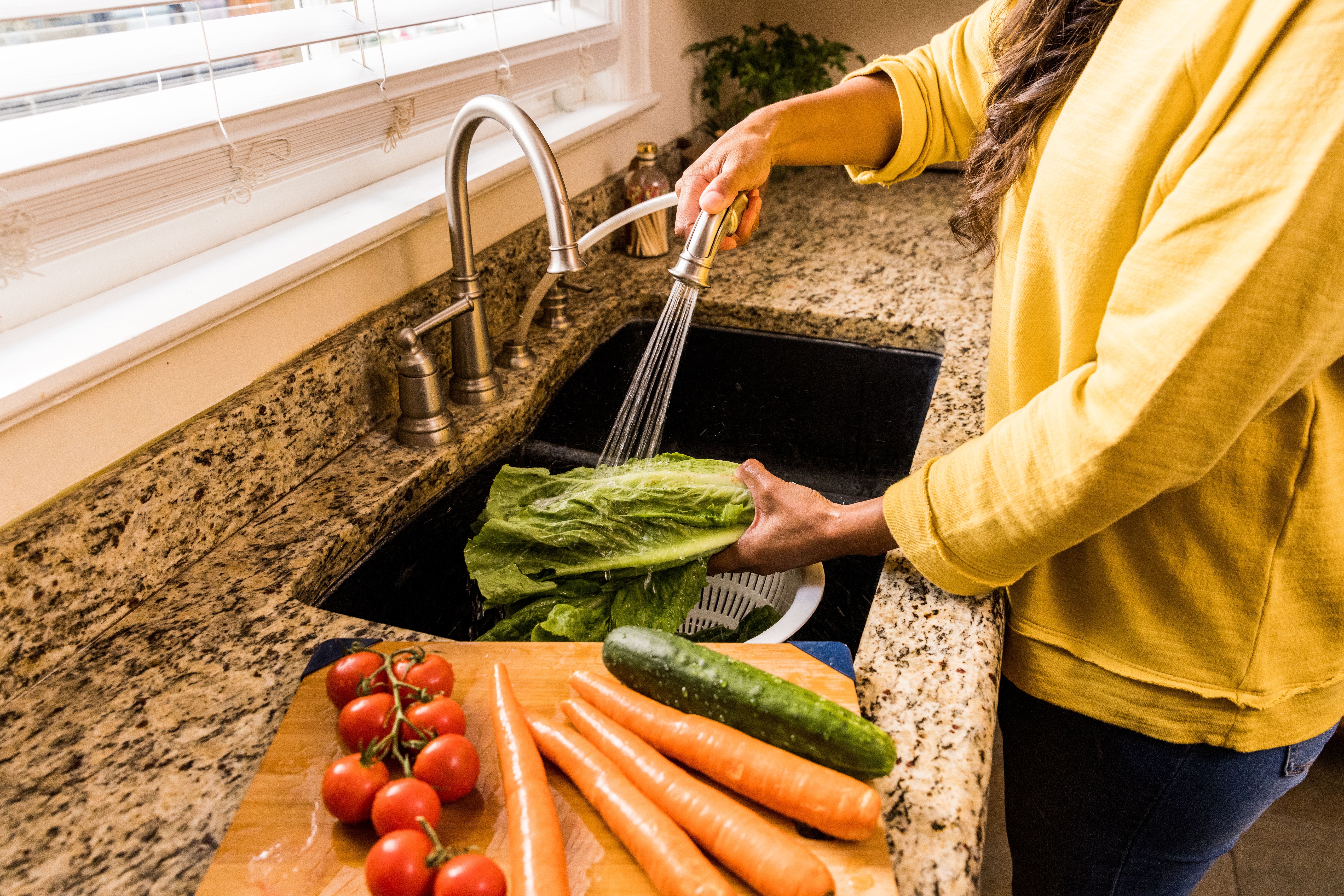 Woman washing food at sink