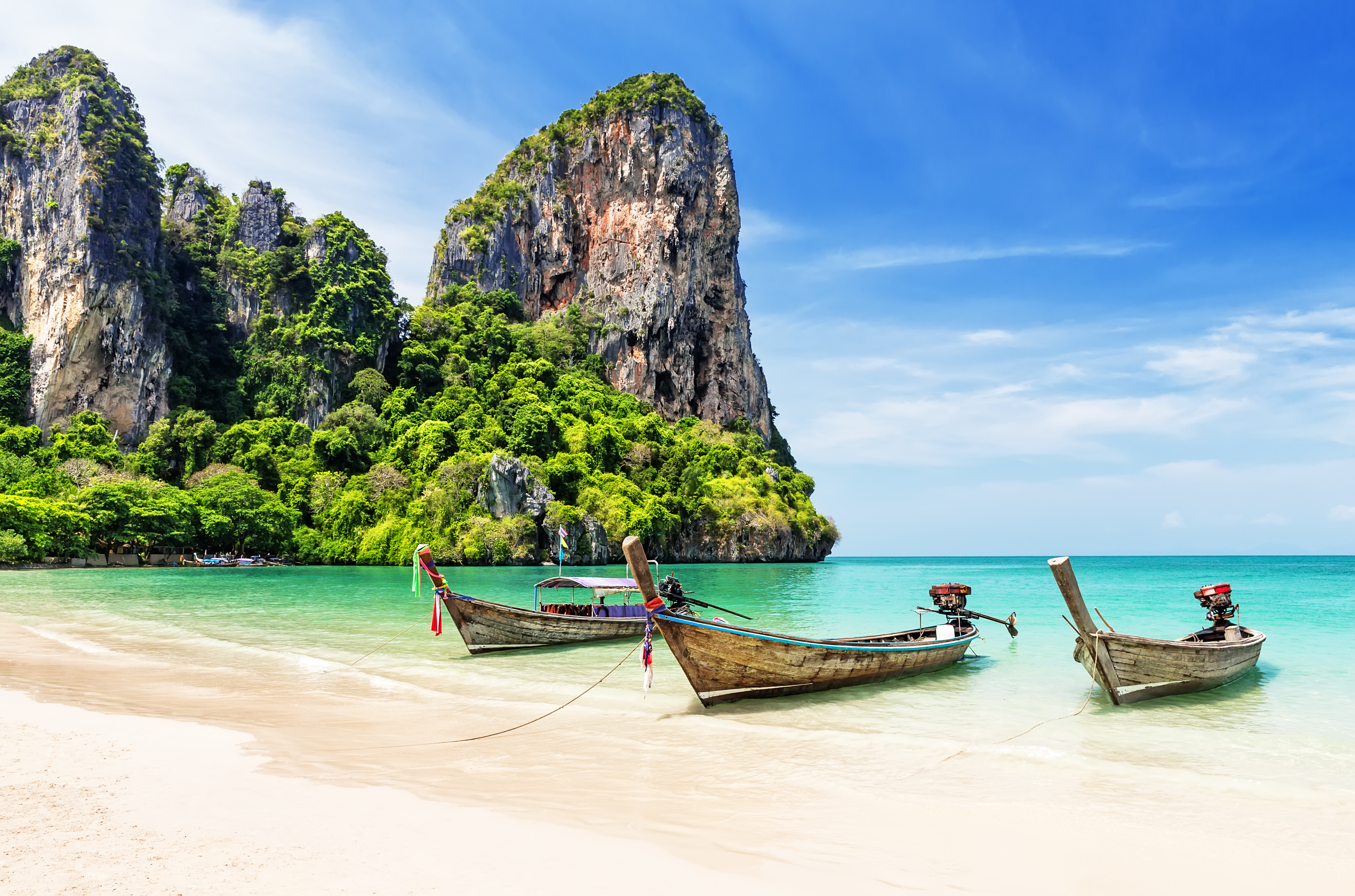 Beach in Phuket, Thailand, with sandy shore and mountains in the background