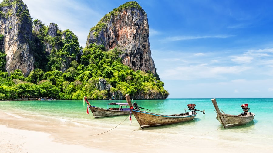 Beach in Phuket, Thailand, with sandy shore and mountains in the background