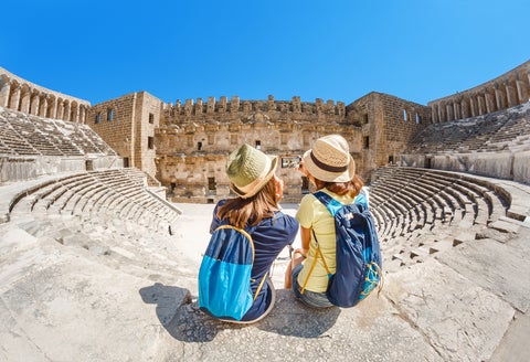 Two young girls student traveler enjoy a tour of the ancient Greek amphitheater