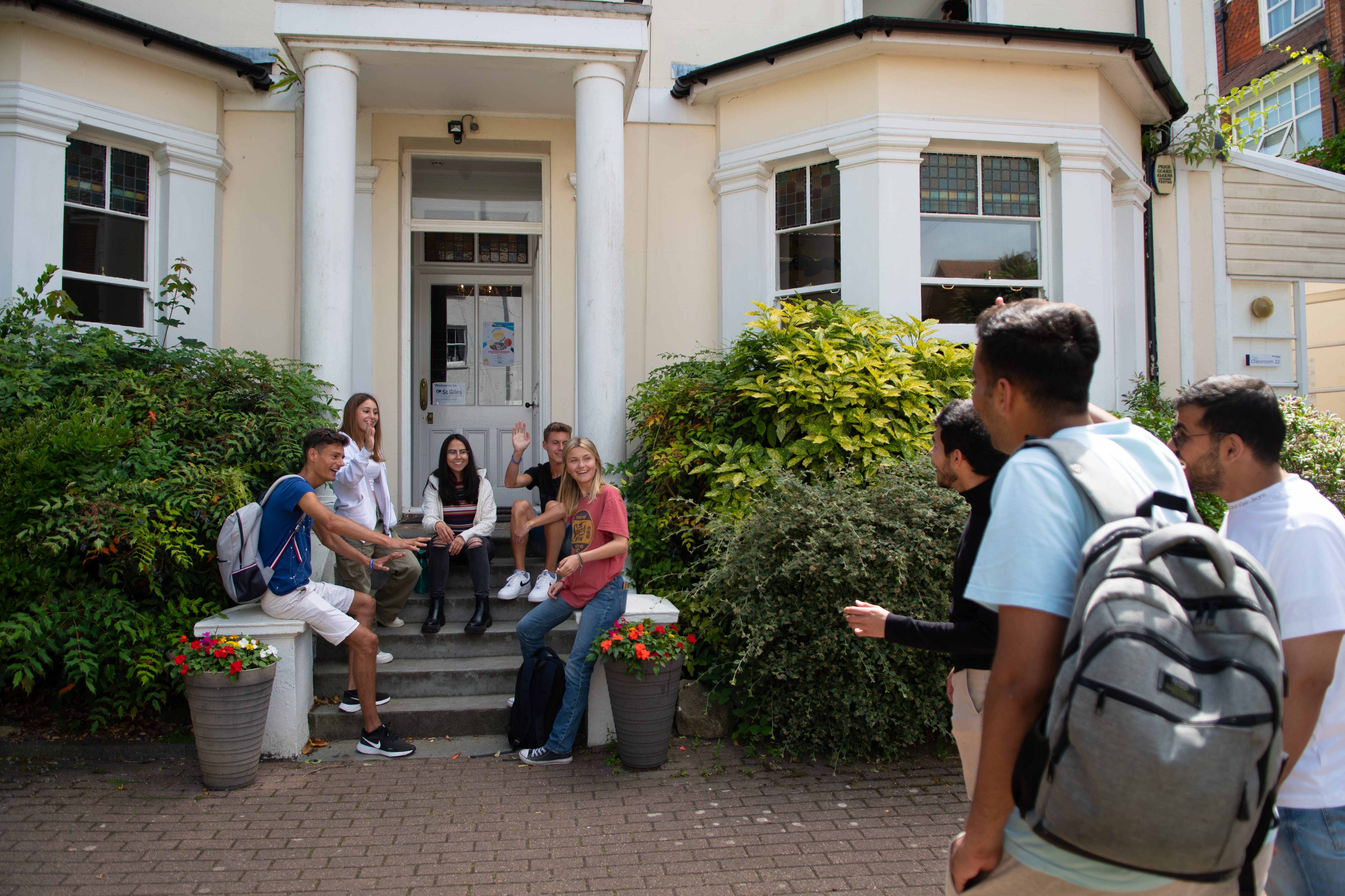 A group of students sitting by the door of the Eastbourne College Programme