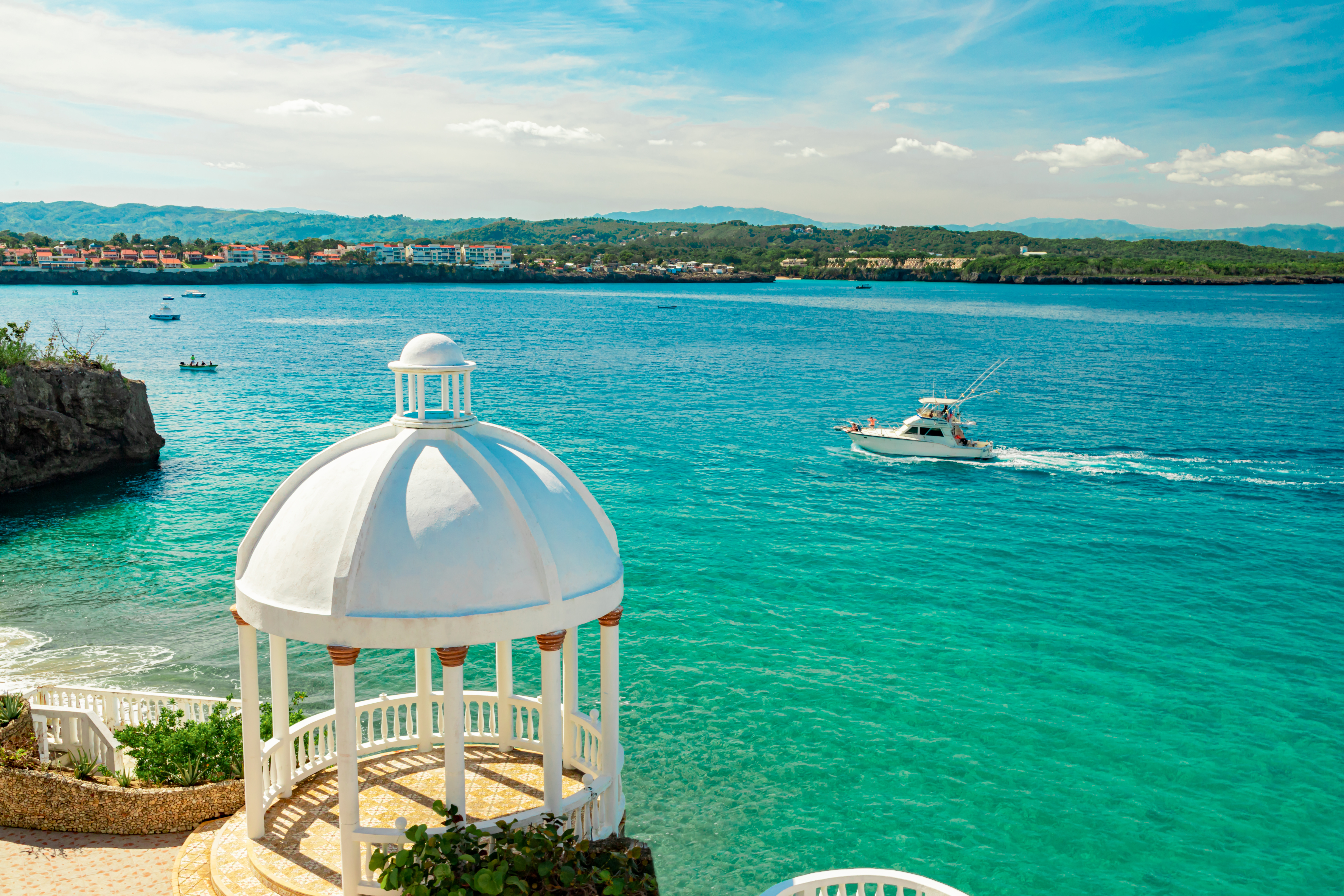 Beautiful white gazebo and tropical flower garden on Caribbean ocean background in Sosua, Puerto Plata, Dominican Republic