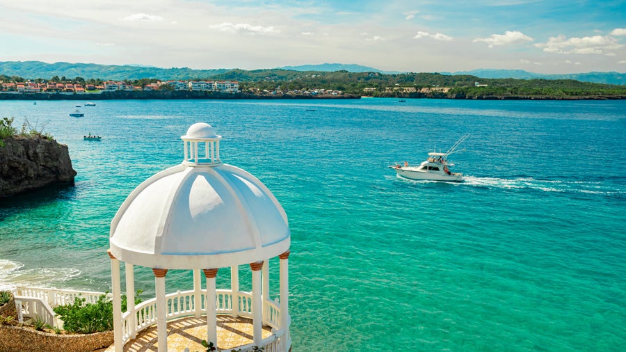 Beautiful white gazebo and tropical flower garden on Caribbean ocean background in Sosua, Puerto Plata, Dominican Republic