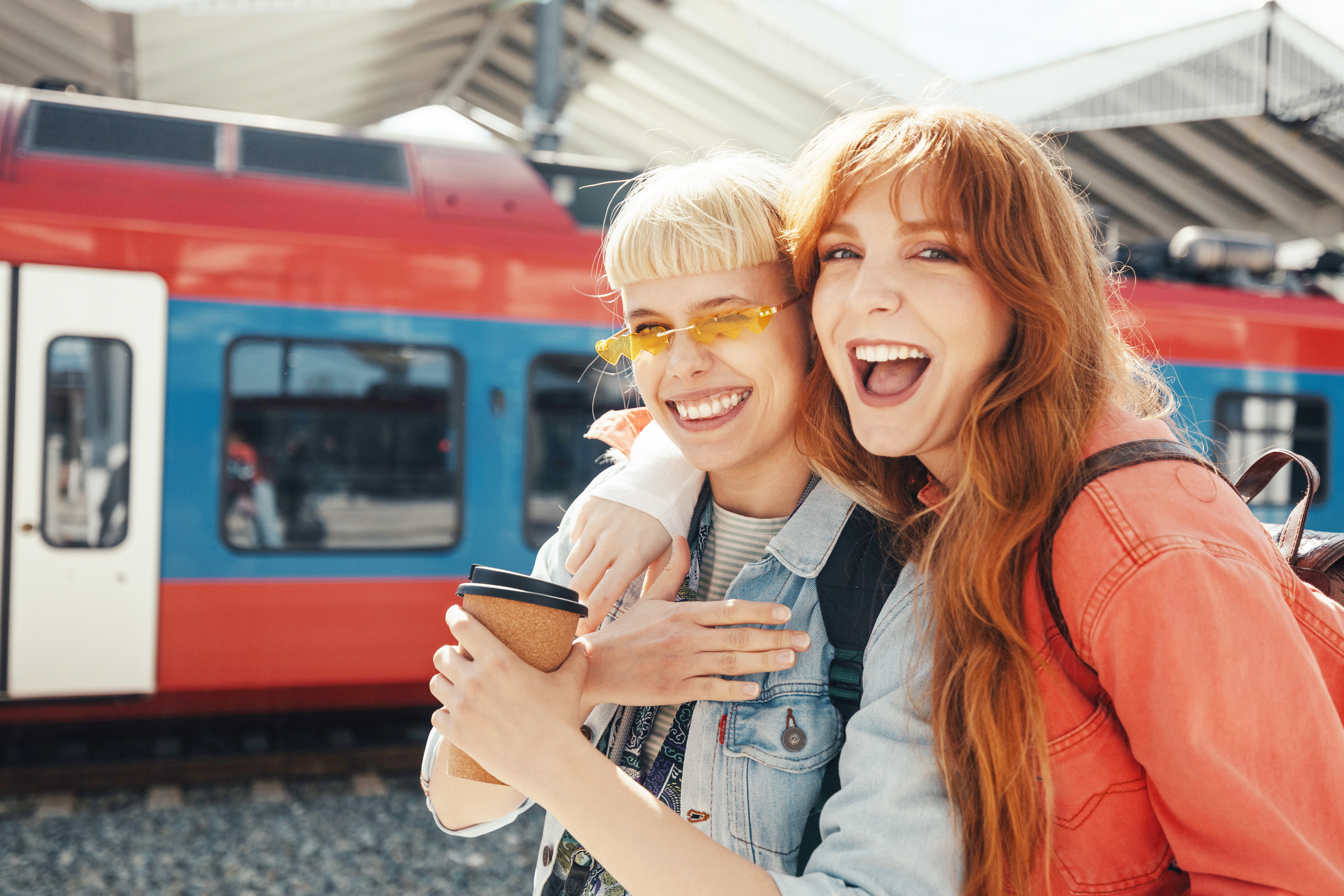 Two friends laughing at a train station