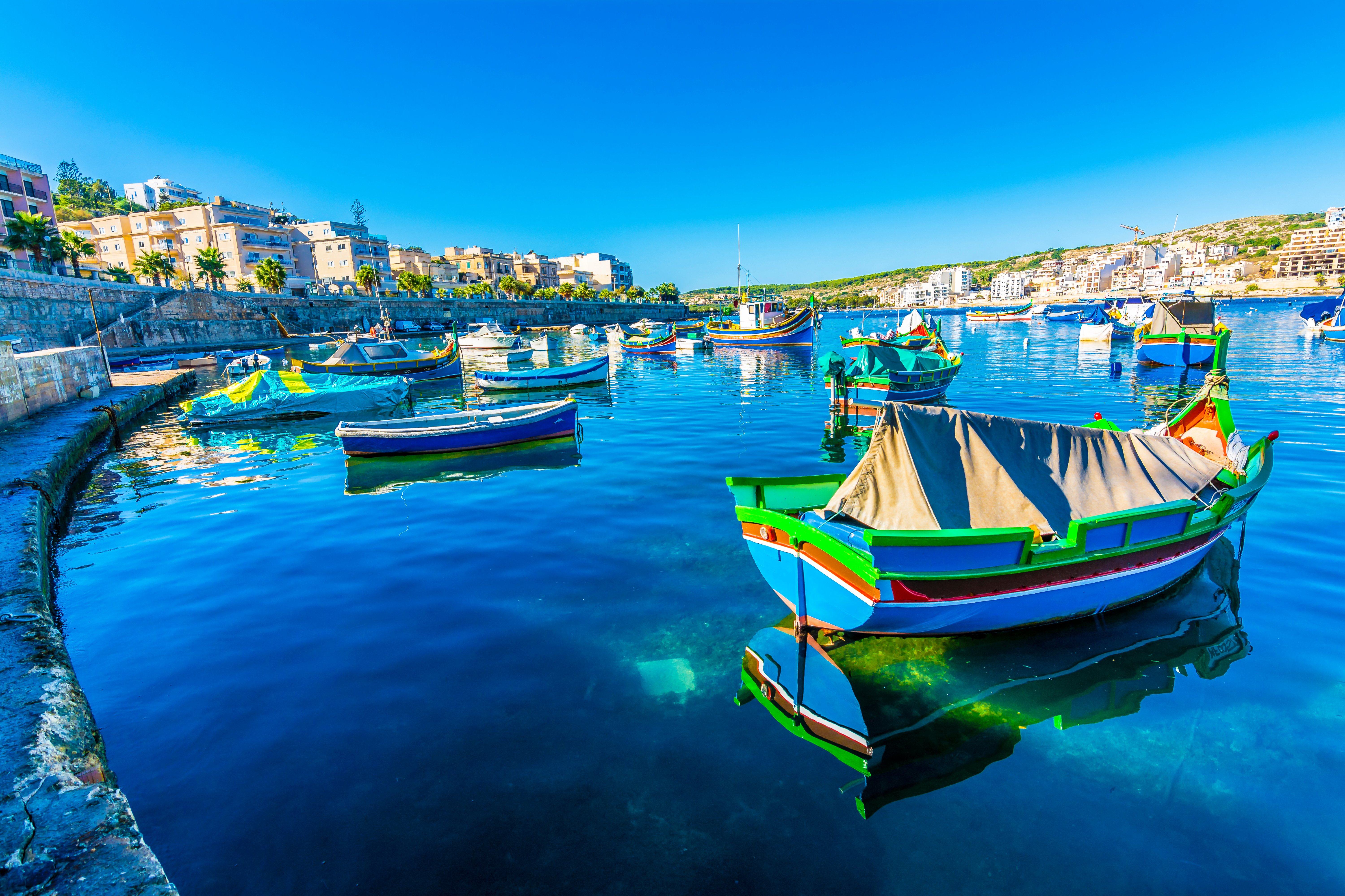 St. Paul’s Bay waterfront in Malta featuring boats and historic buildings  along the coastline