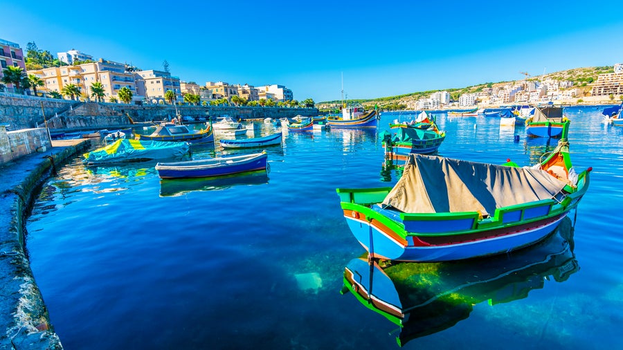 St. Paul’s Bay waterfront in Malta featuring boats and historic buildings  along the coastline