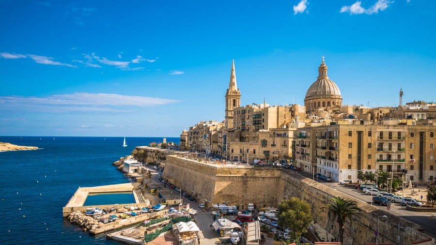 St. Paul’s Bay waterfront in Malta featuring historic buildings including Wignacourt Tower along the coastline