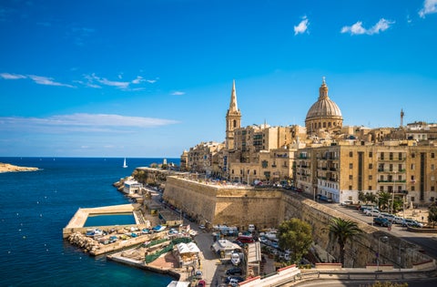 St. Paul’s Bay waterfront in Malta featuring historic buildings including Wignacourt Tower along the coastline