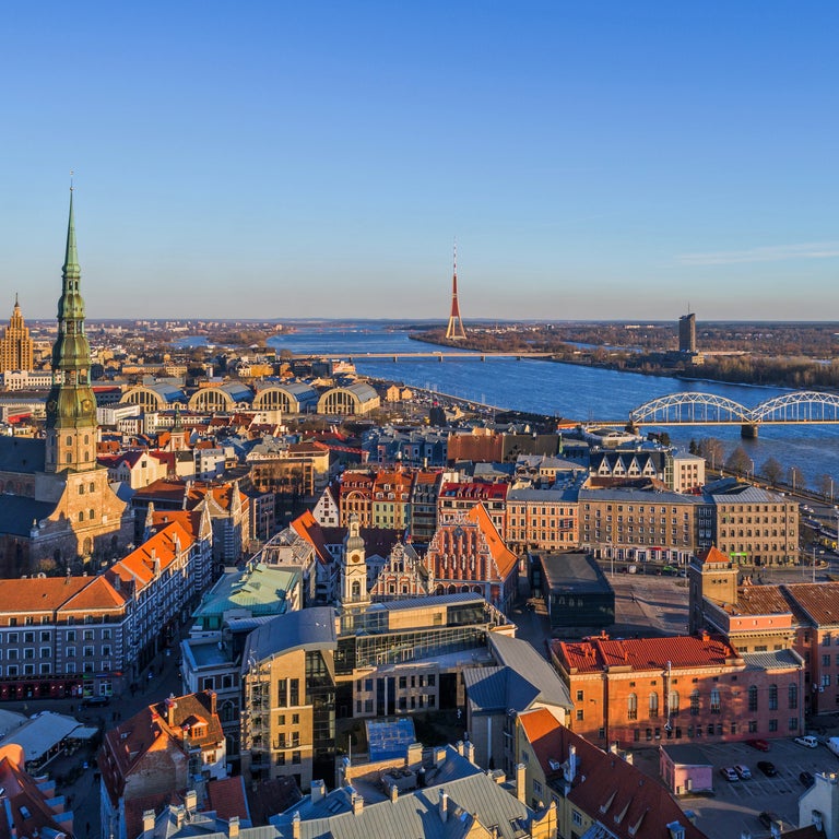 Aerial view of Riga, Latvia, showing the Daugava River, Vanšu Bridge, and the Riga Cathedral in the historic city center