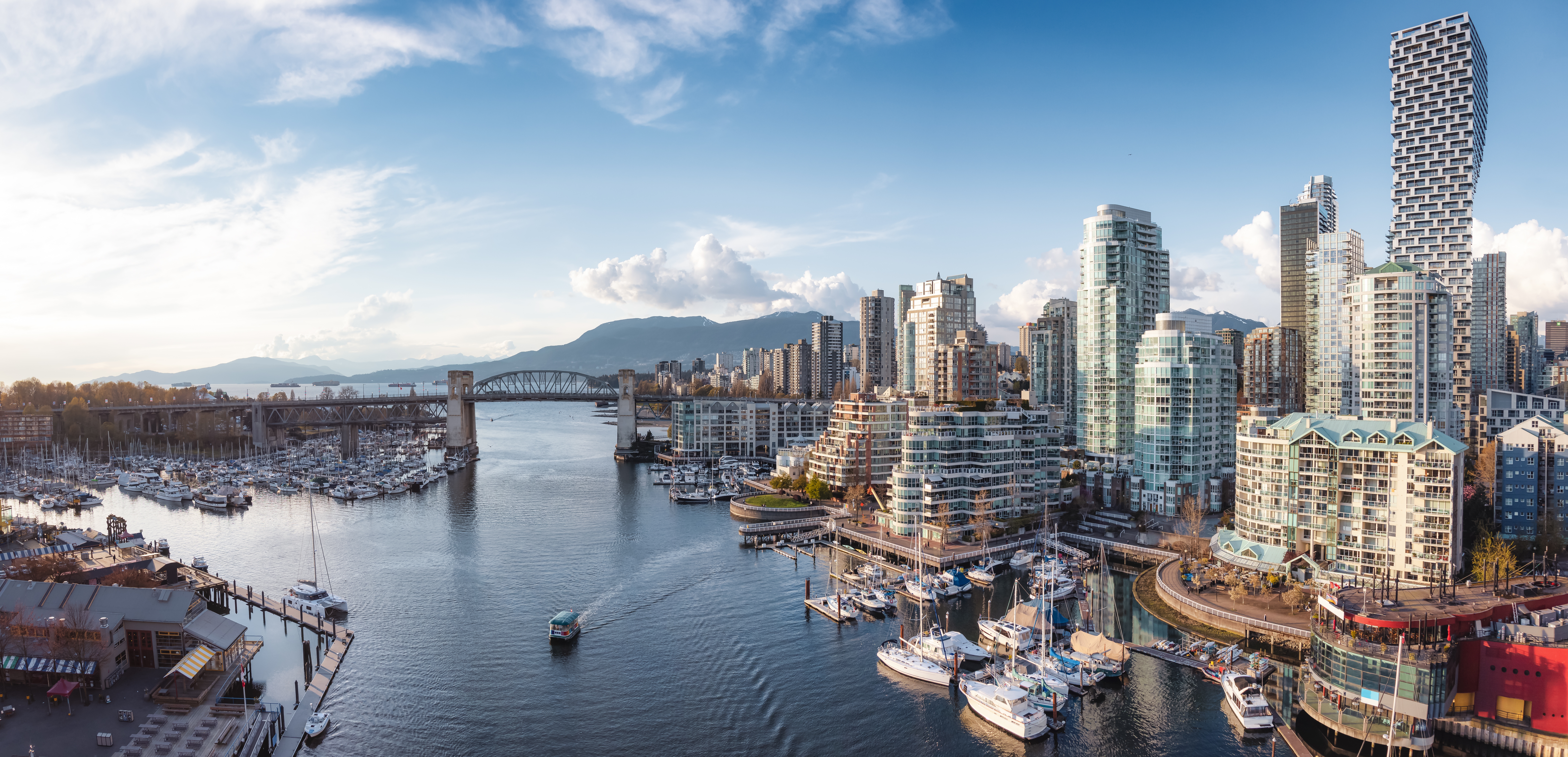 Vancouver False Creek waterfront with modern buildings and a bridge reflecting on the water