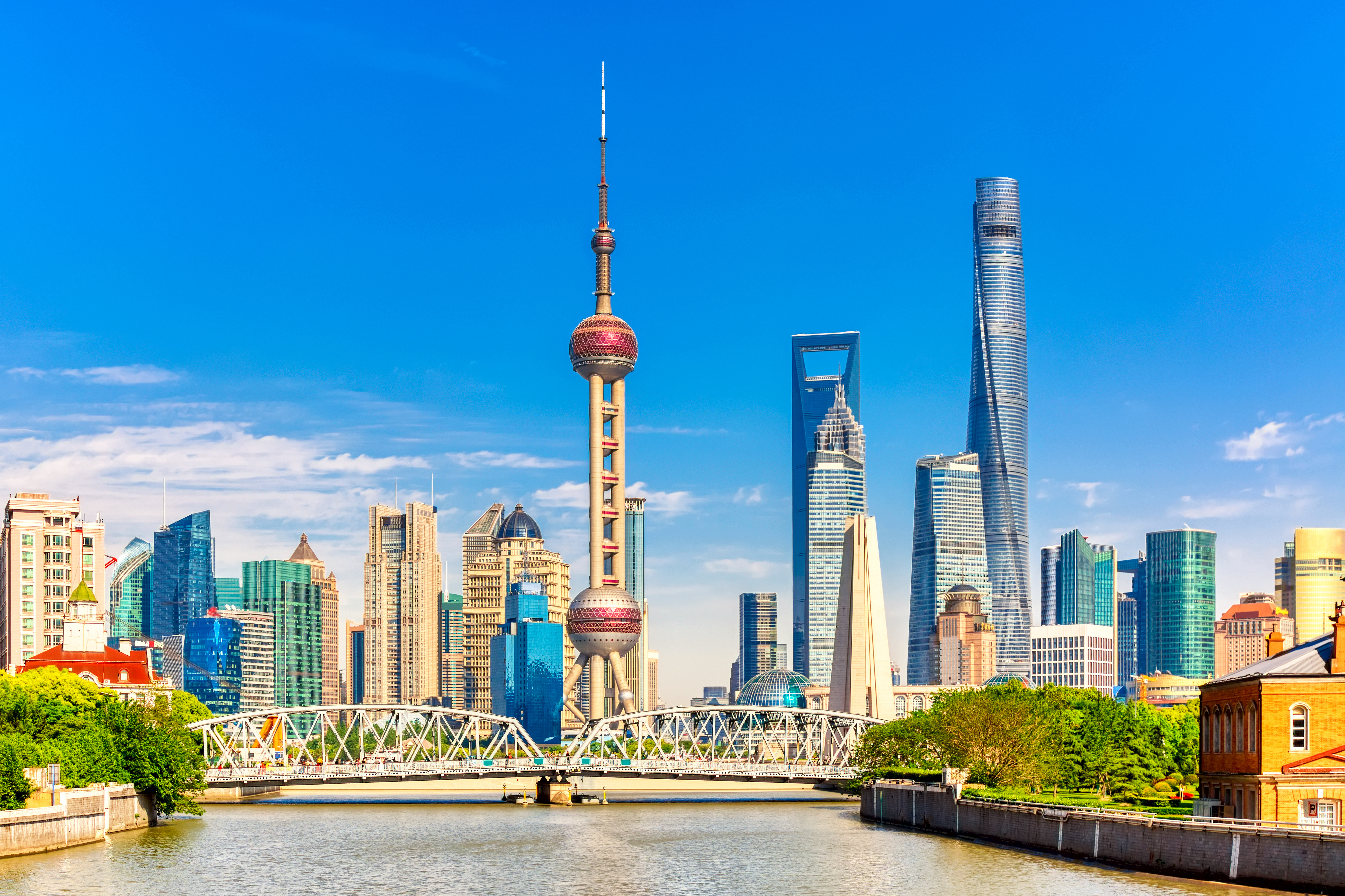 Aerial view of urban landscape with towering skyscrapers, modern shopping complexes, and Huangpu River in Shanghai, China