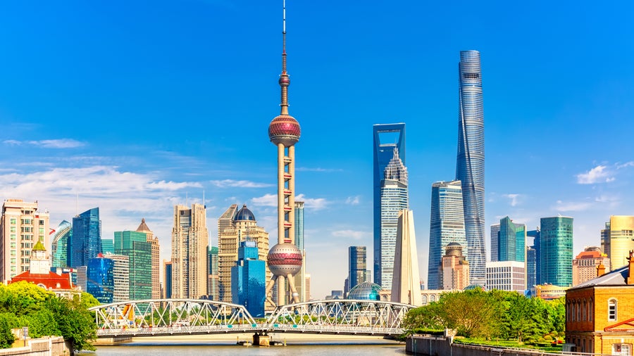 Aerial view of urban landscape with towering skyscrapers, modern shopping complexes, and Huangpu River in Shanghai, China