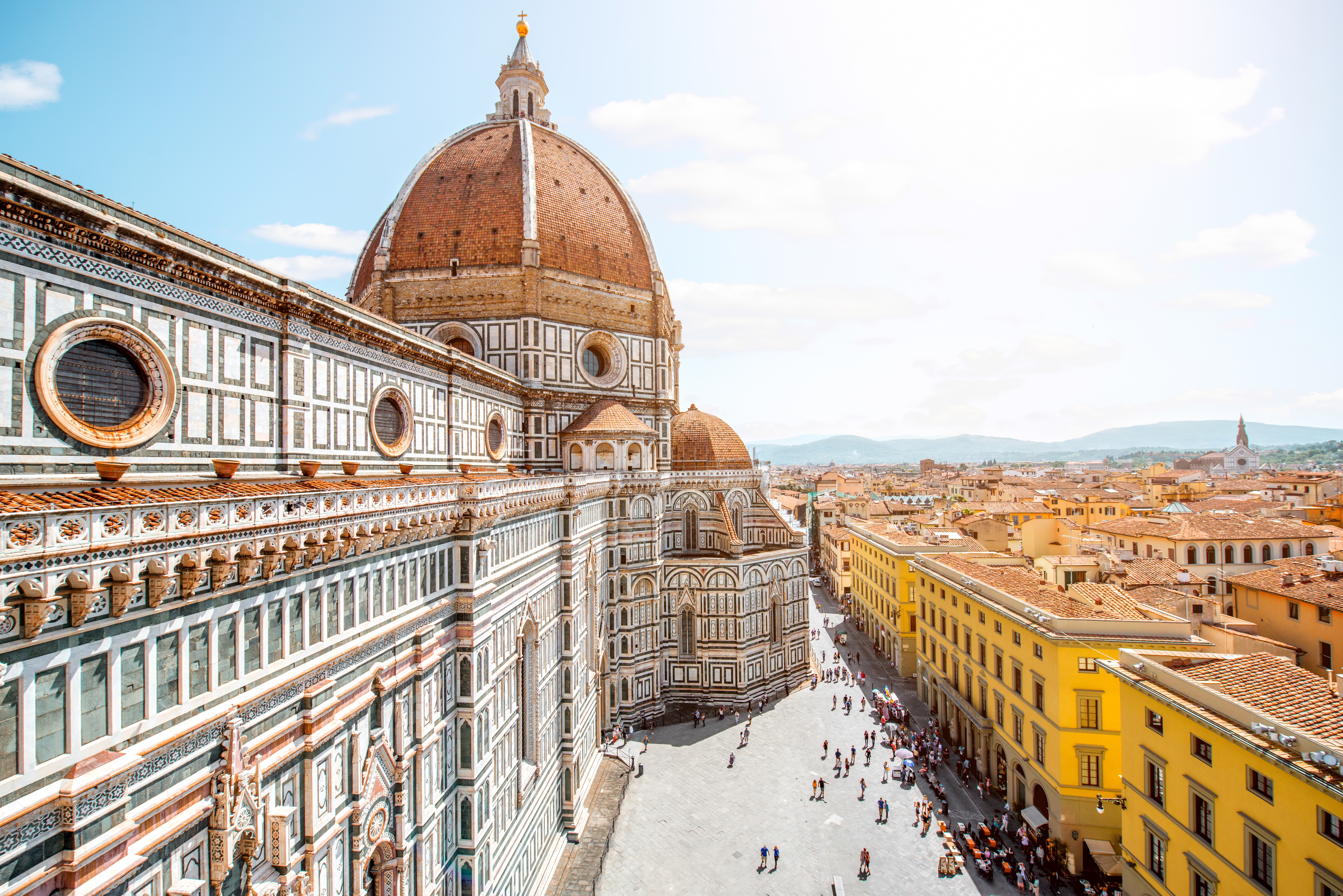 Aerial view of Piazza del Duomo in Florence featuring Cathedral (Duomo) with its iconic red dome, the intricate marble facade of the Baptistery of St. John
