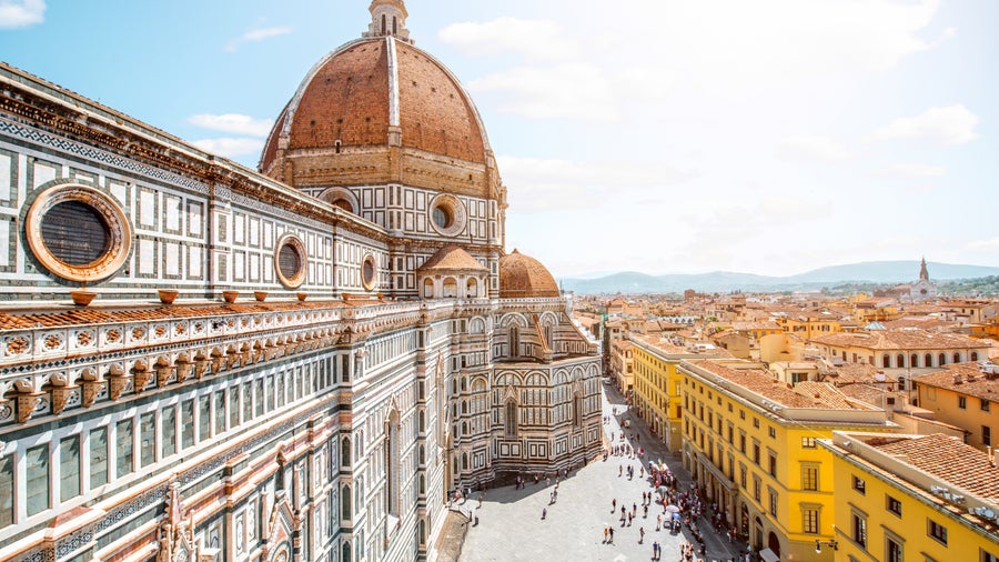 Aerial view of Piazza del Duomo in Florence featuring Cathedral (Duomo) with its iconic red dome, the intricate marble facade of the Baptistery of St. John