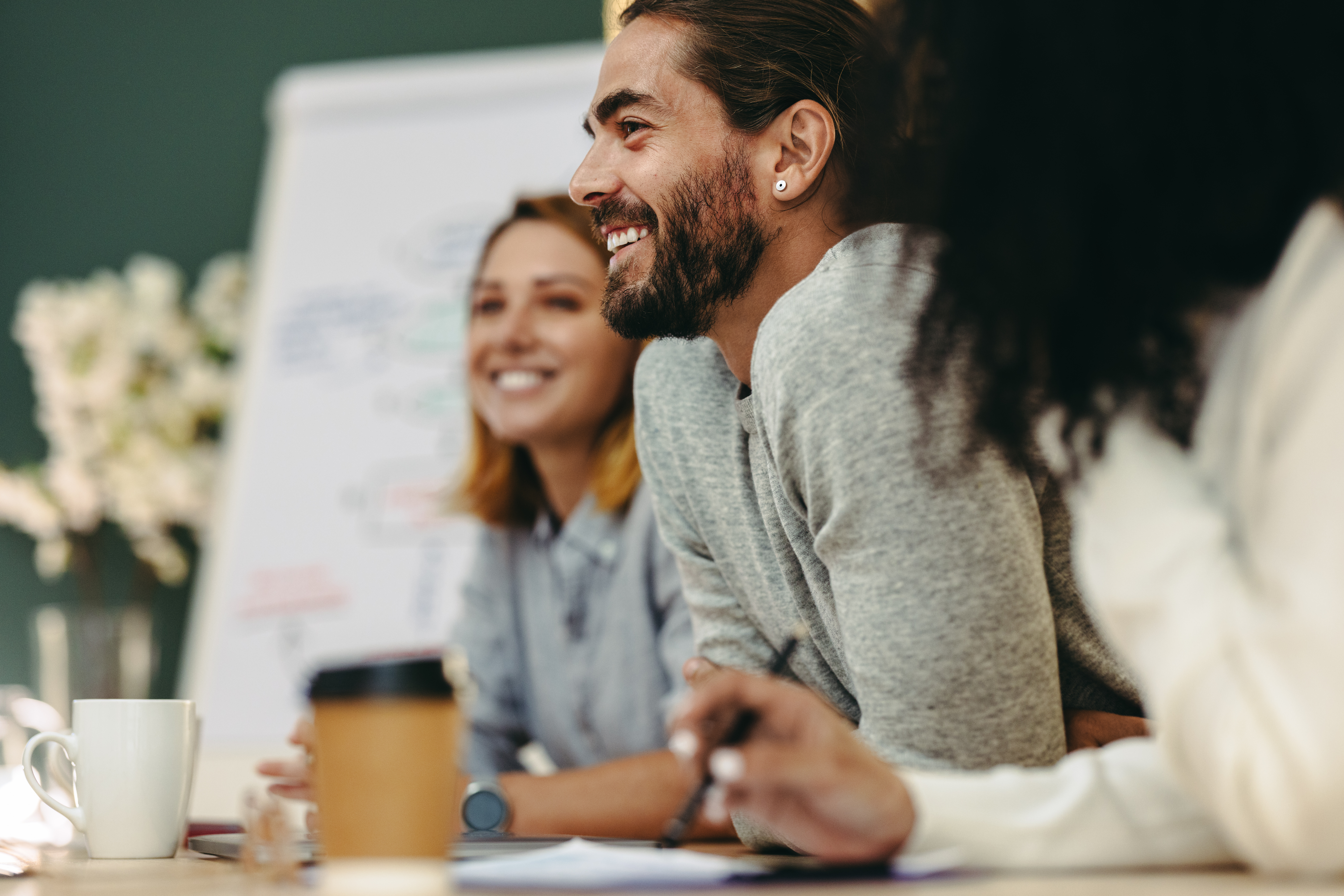 Happy young businessman attending a meeting with his team in a professional setting
