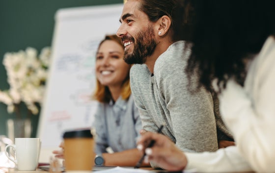 Happy young businessman attending a meeting with his team in a professional setting