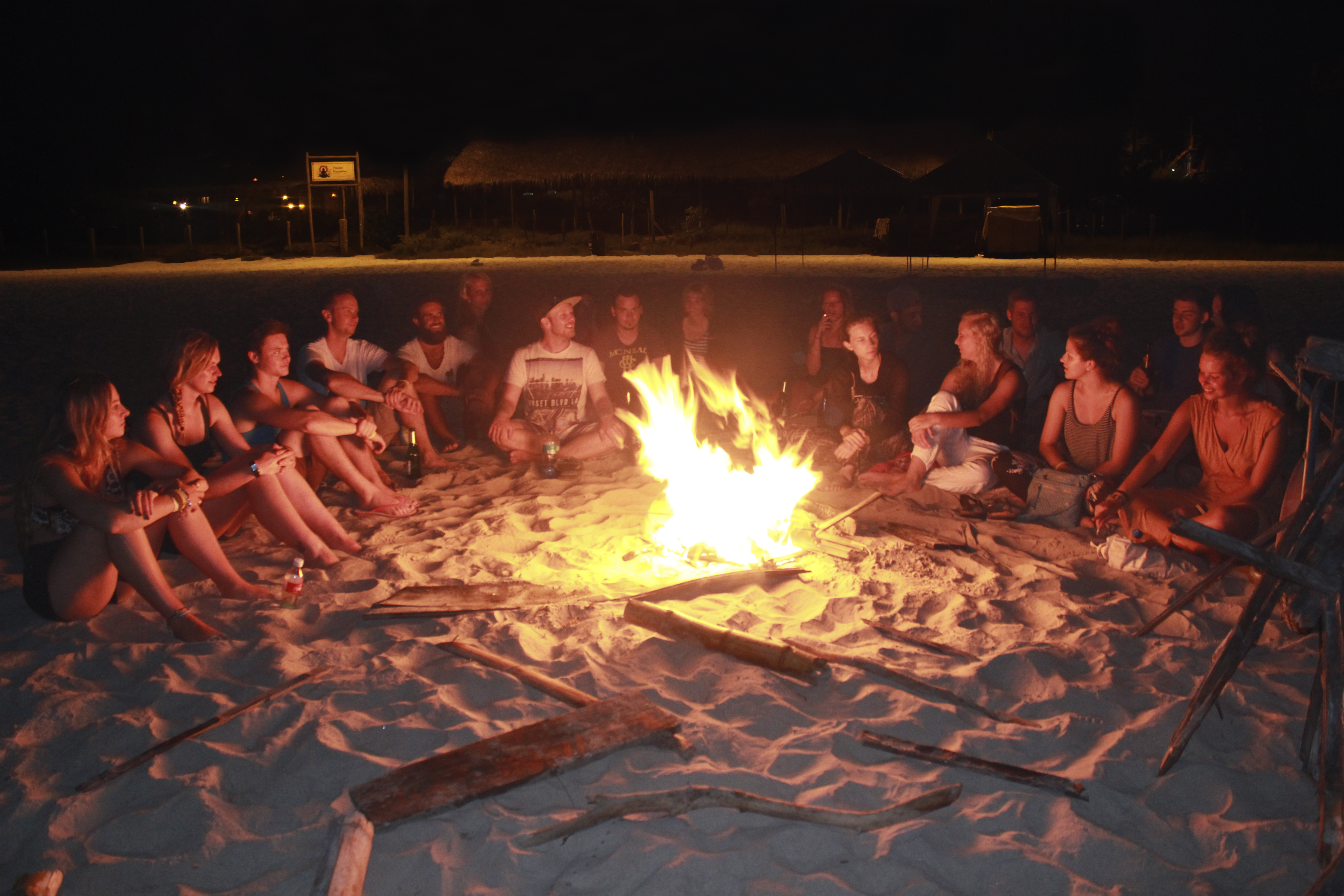 A group of students around a bonfire at the beach