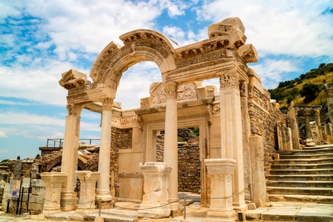 Library of Celsus in ancient Ephesus, Turkey, featuring grand Roman facade with carved columns and statues amid ancient ruins and Anatolian plateau backdrop