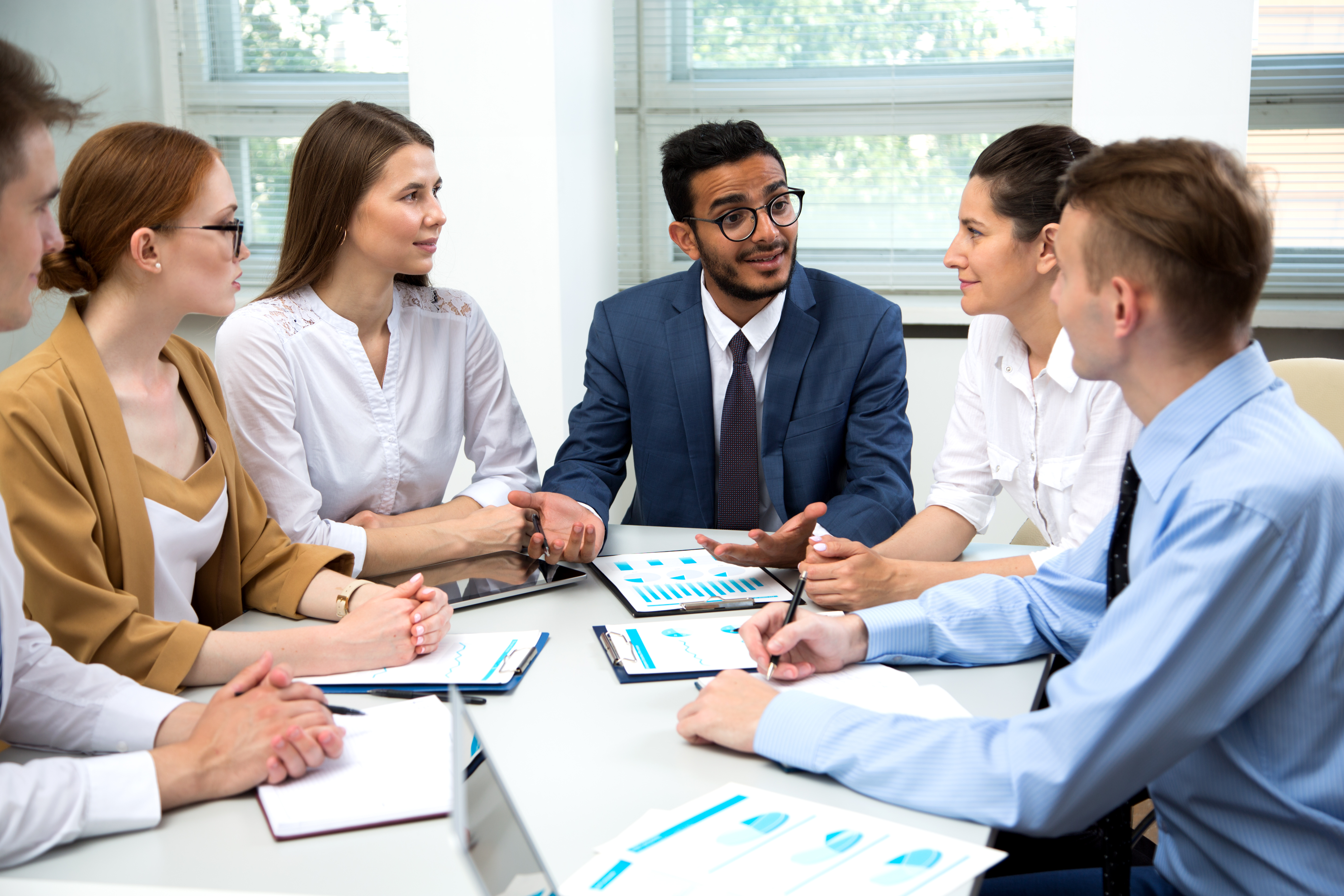 Business meeting in the office with all team members seated around a desk