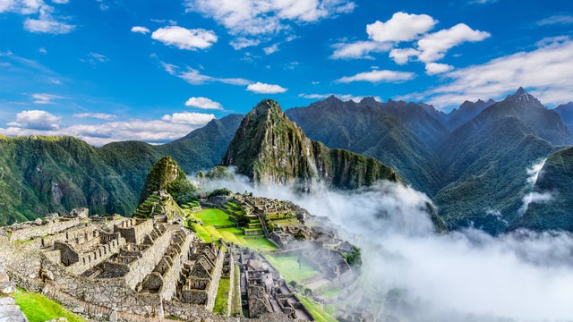 Panoramic view of Machu Picchu ruins in Peru with lush green mountains in the background, UNESCO World Heritage site