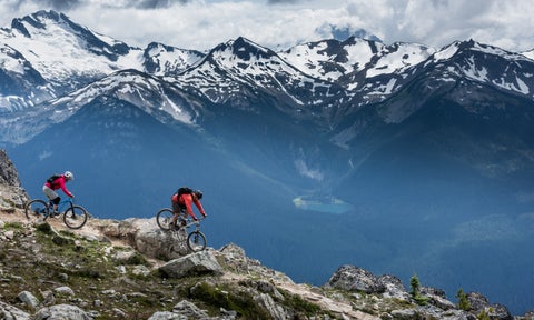 Bikers riding across snowy slopes of Blackcomb Mountain in Whistler, Canada, known for its alpine trails and adventure sports