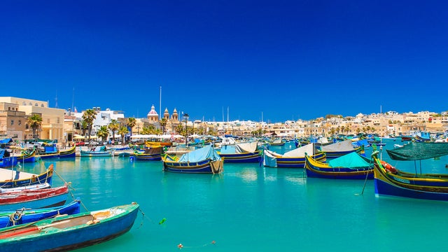 Boats in Malta harbor with historic city center in the background