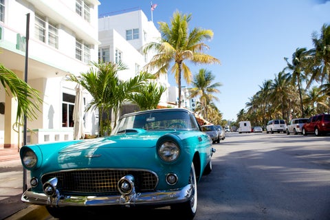 Vintage American car on Miami street with tropical backdrop in Florida, USA